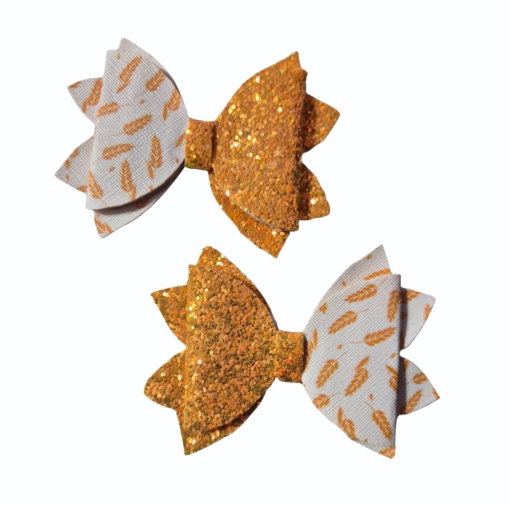Handmade 2-pack medium faux leather hair bow set featuring gold glitter and autumn leaf print for babies, toddlers, and girls.