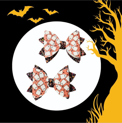 Two handmade Halloween ghost print medium hair bows with black glitter accents for babies, toddlers, and little girls.
