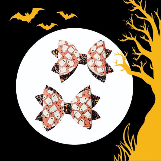 Two handmade Halloween ghost print medium hair bows with black glitter accents for babies, toddlers, and little girls.