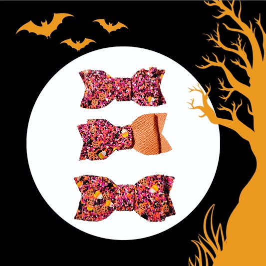 Three handmade Halloween mini glitter hair bows (3 pack) in orange and purple with spooky Halloween prints for babies, toddlers, and little girls.