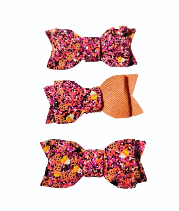 Three handmade Halloween mini glitter hair bows (3 pack) in orange and purple with spooky Halloween prints for babies, toddlers, and little girls.