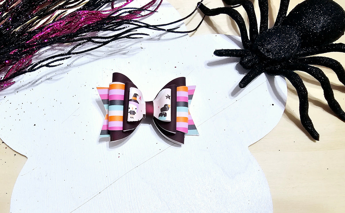 Boutique mini Halloween hair bow for babies and girls with a colorful spooky season design.