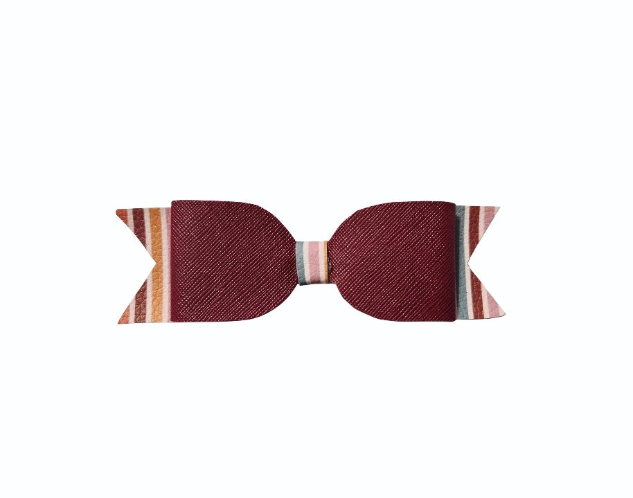Burgundy ribbon backing of a handmade striped fall hair bow with a light-colored center wrap.