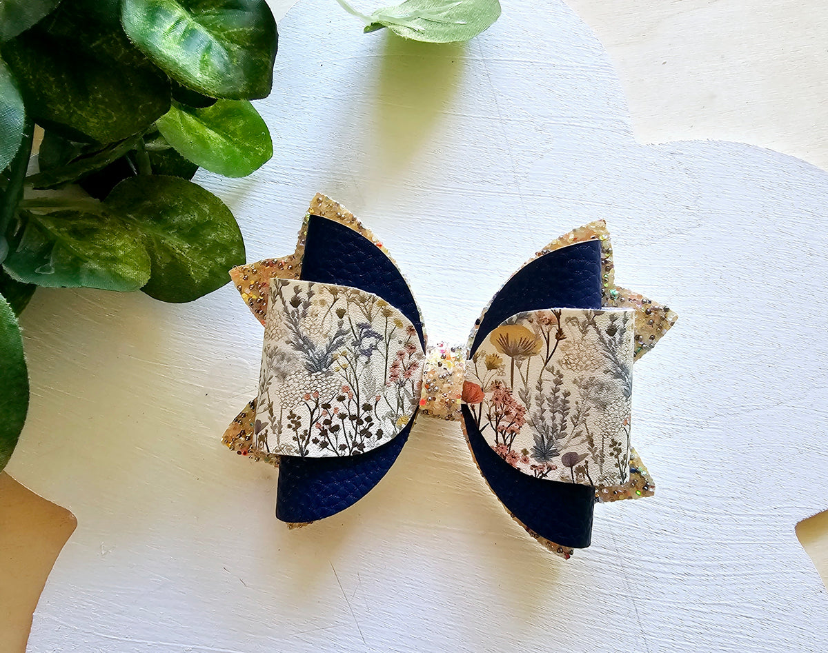 Handmade Floral Forage faux leather boutique hair bow with delicate wildflower print and navy accents.