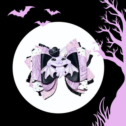 Cute pastel bat Halloween hair bow handmade for girls with black and lavender faux leather.