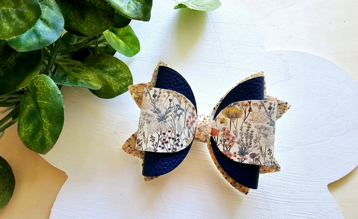 Handmade Floral Forage faux leather boutique hair bow with delicate wildflower print and navy accents.