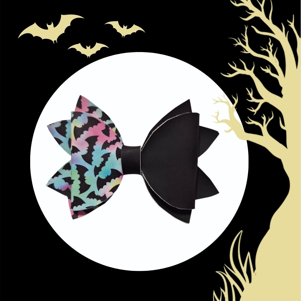 Two medium heat changing bat hair bows in pastel Halloween colors.
