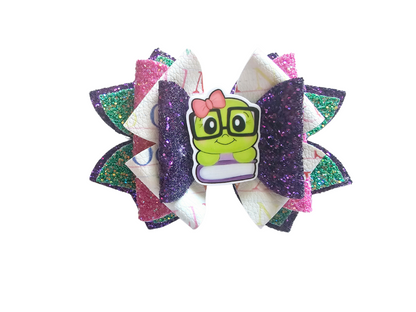 Handmade bookworm hair bow with glitter faux leather layers for girls, perfect for back-to-school outfits, picture day, and young readers.  