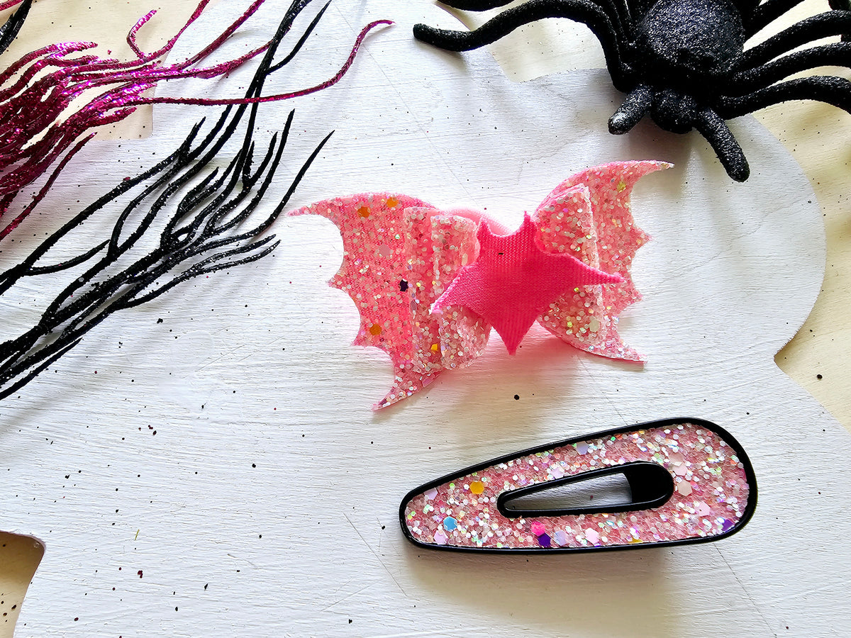 Handmade vampire bat ponytail holder that glows in the dark for spooky season outfits.