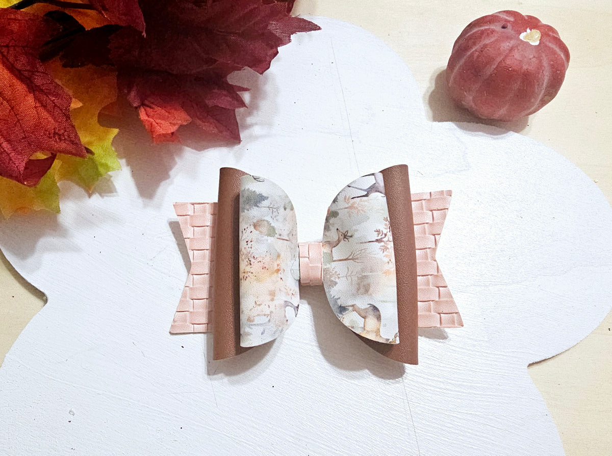 Handmade watercolor deer faux leather boutique hair bow with soft woodland colors for girls.