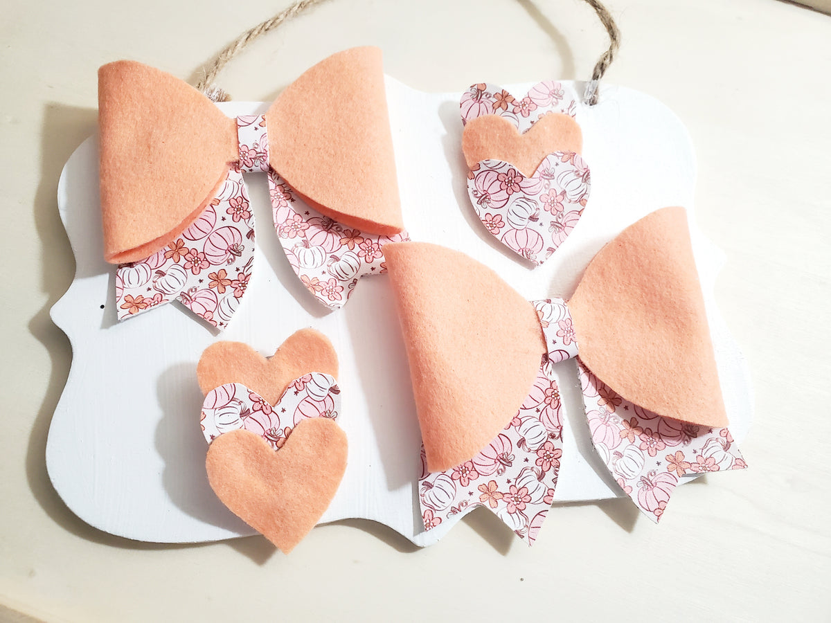Four-piece fall hair accessory set featuring two peach bows with pumpkin floral print accents and two coordinating hair clips.