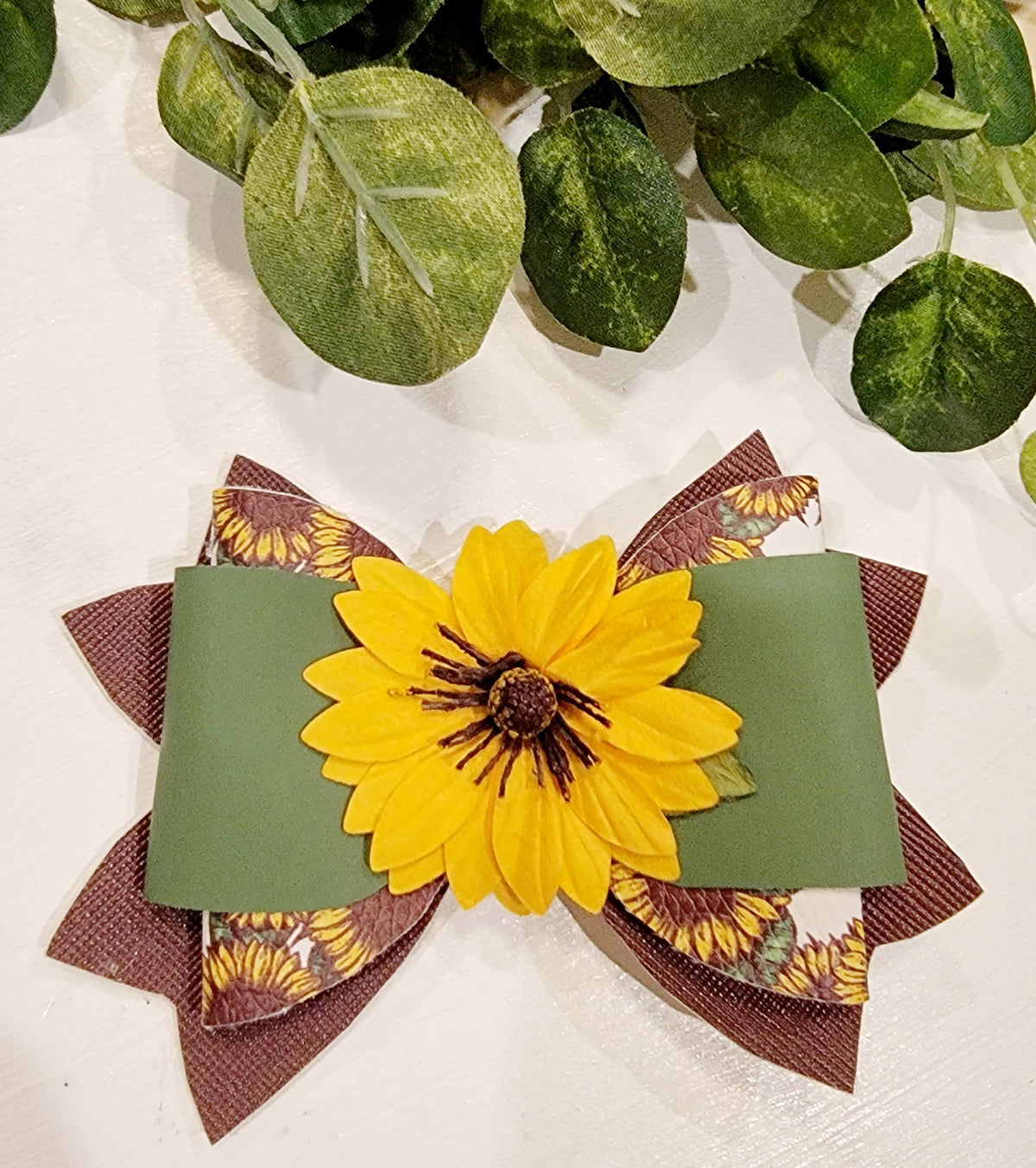 Handmade girls' sunflower hair bow with a large yellow flower, sage green ribbon and layered brown fall accents.