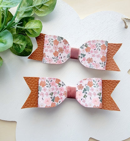 Handmade pink floral fabric wristlet with a gold-tone metal clasp displayed on a white background.