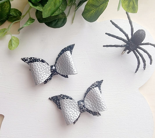 Handmade mini bat hair bows in silver faux leather, perfect for Halloween costumes and spooky season.