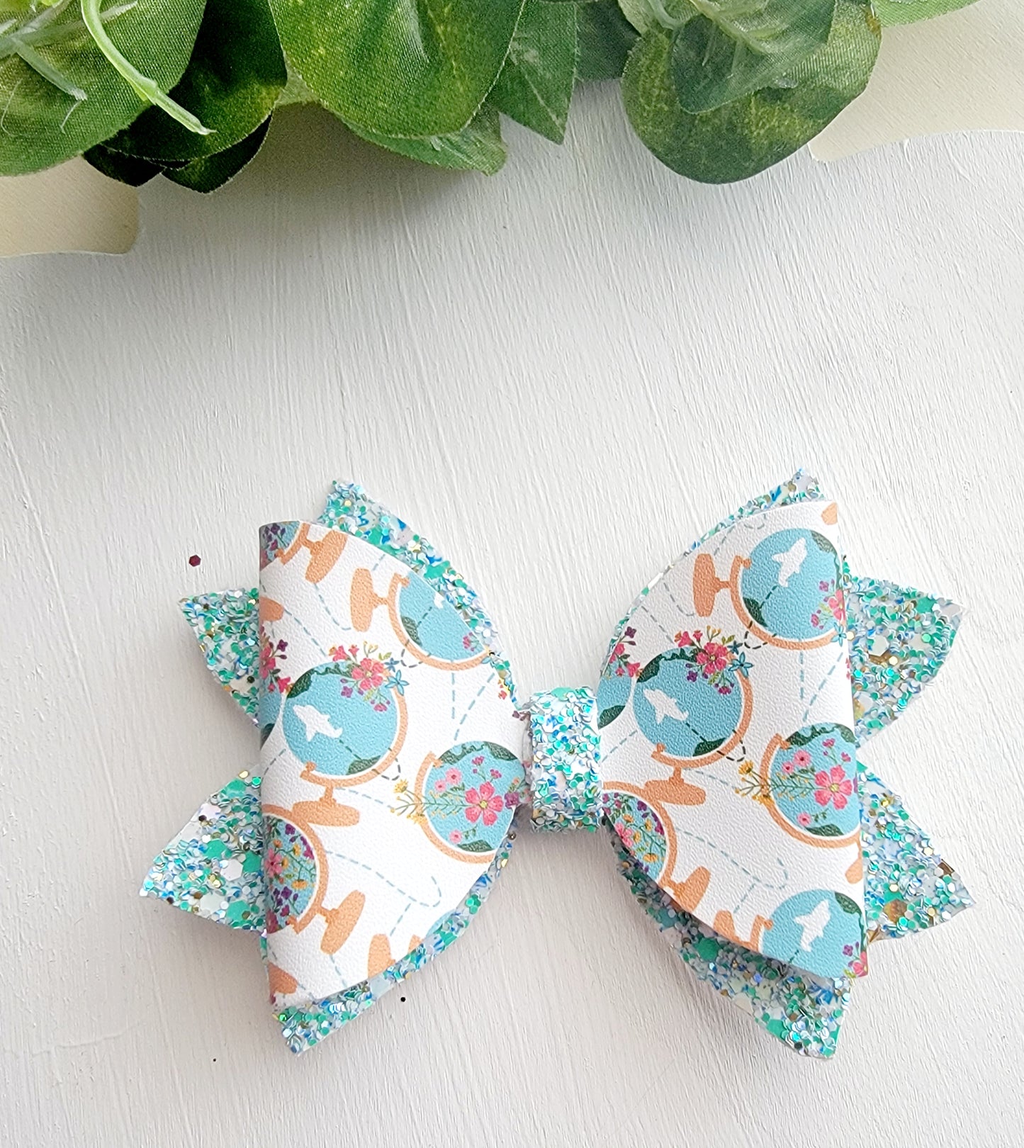 Handmade world globe and airplane hair bow for girls, perfect for back-to-school outfits, picture day, and classroom-themed accessories.